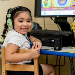 Young student at computer wearing headphones